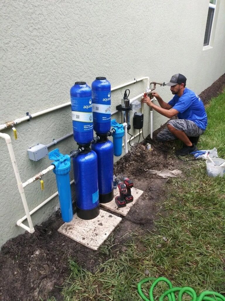 Plumber finishing a new water filtration system installed at a residential home to improve water quality